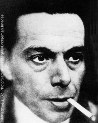 Photographie historique en noir et blanc représentant un gros plan de l'artiste et expressionniste allemand Ernst Ludwig Kirchner, une cigarette à la bouche.