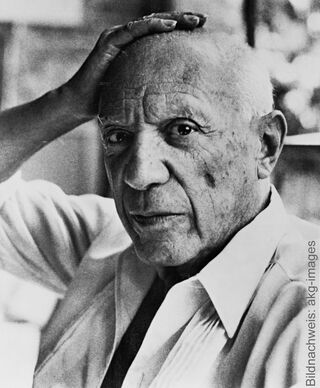 A historical black-and-white portrait of the Spanish artist Pablo Picasso, who is thoughtfully resting his hand on his head.